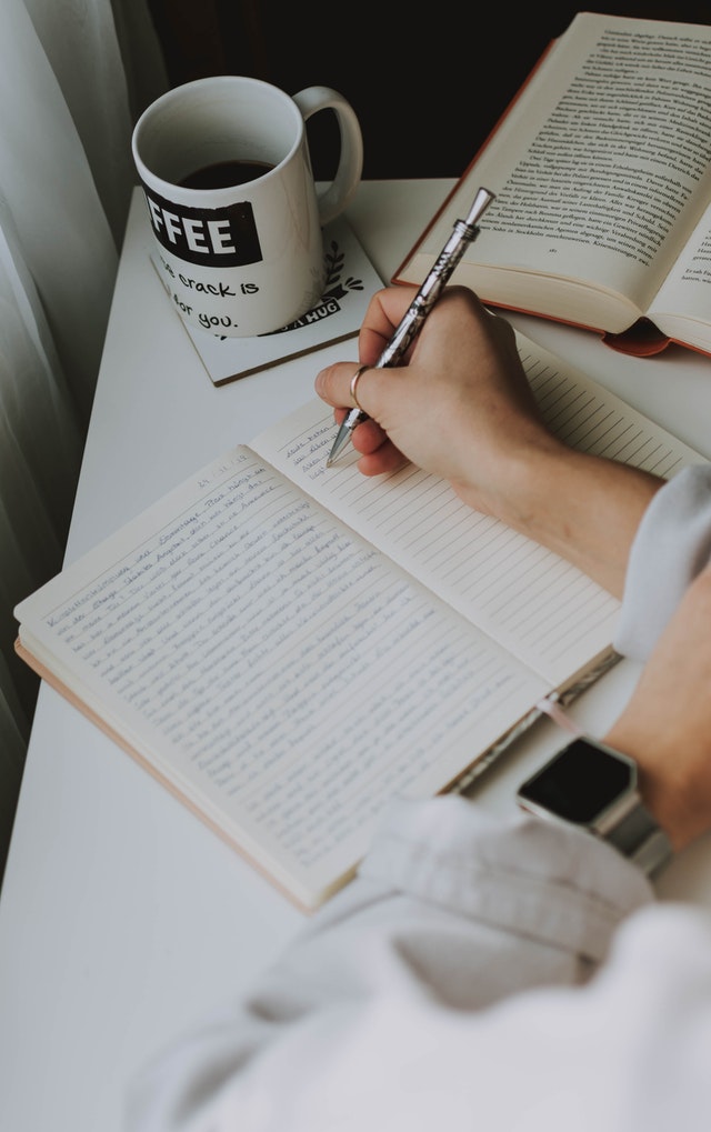 person writing on notebook