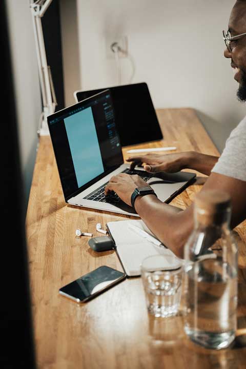 person-using-macbook-pro-on-brown-wooden-table